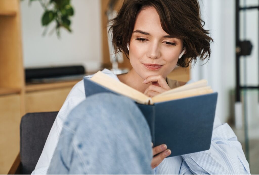 Young smiling lady reading some Self Help books