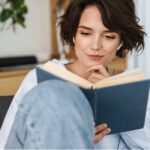 Young smiling lady reading some Self Help books